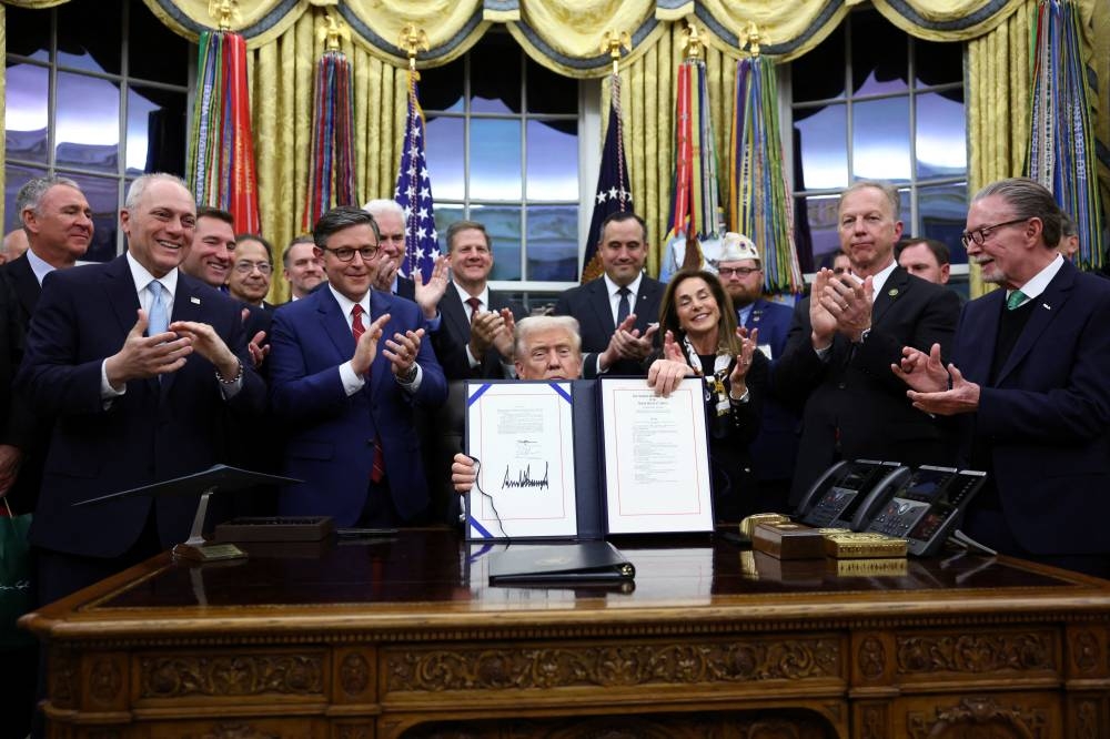 U.S. President Donald Trump poses for a photo after he signs the funding bill to end the U.S. government shutdown, at the White House in Washington, D.C., U.S., November 12, 2025. REUTERS