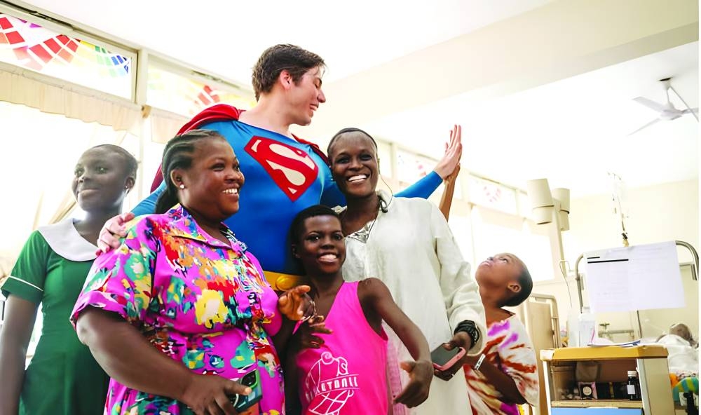 Leonardo Muylaert, known as the Brazilian Superman, poses with patients and their relatives during a visit at the Korle Bu Teaching Hospital in Accra, recently.