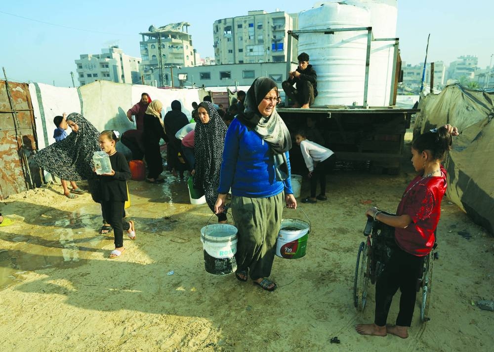 Palestinians gather to collect water, amid a ceasefire between Israel and Hamas, in Gaza City, Wednesday.