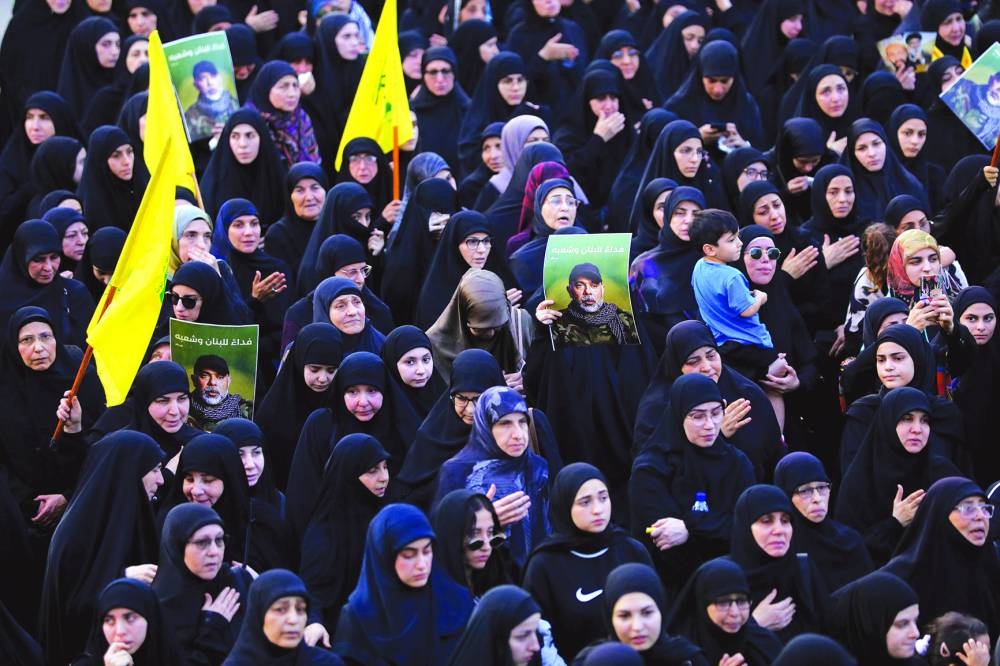 Mourners carry pictures of slain Hezbollah chief Haytham Ali Tabatabai, who was killed in an Israeli strike a day earlier, during his funeral in Beirut’s southern suburbs on November 24, 2025. Hezbollah held the funeral on November 24 for its top military chief and other members of the militant group a day after Israel killed them in a strike on Beirut's southern suburbs. (AFP)
