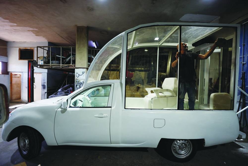 A Palestinian cleans the Vehicle of Hope, the former popemobile used by Pope Francis, which has been transformed into a fully equipped mobile clinic, in Bethlehem in the occupied West Bank.