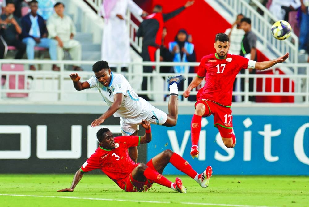 Somalia's Yusuf Ali in action with Oman's Thani Gharib al-Rushaidi and Ali al-Busaidi during the FIFA Arab Cup match at the Abdulah bin Khalifa Stadium. (Reuters)
