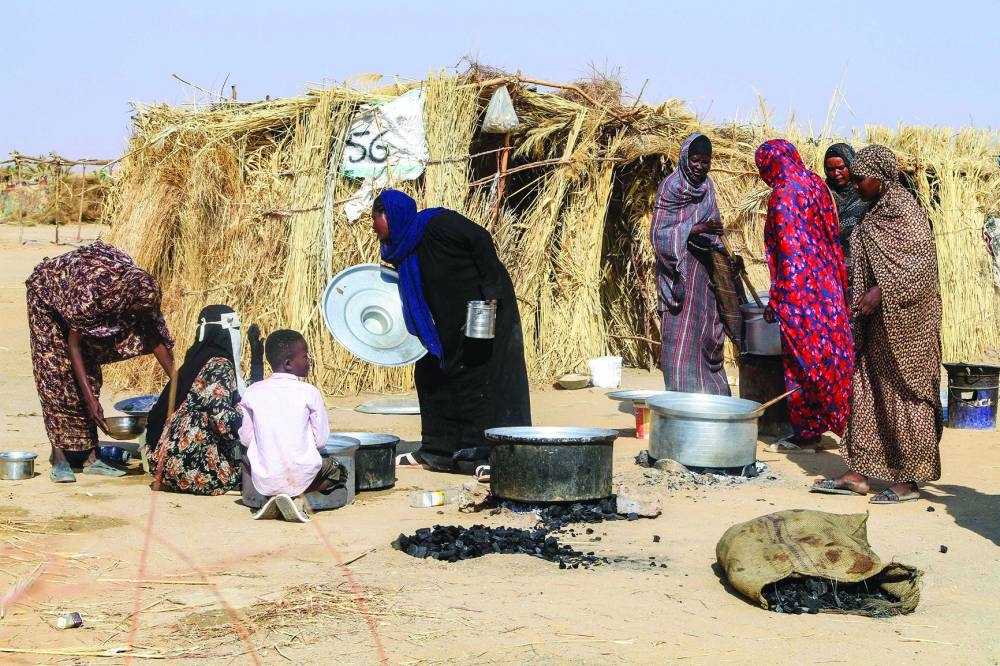 
Sudanese people who fled El-Fasher prepare a meal at a camp for displaced Sudanese people in the northern town of Al-Dabba. (AFP/File Photo) 
