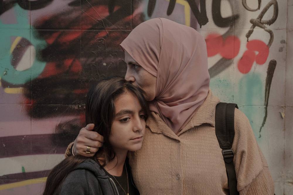 Palestinian refugees Argwan al-Fara, 11 (left), and her mother Shadia al-Fara, 44, who now live in Athens, pose for a portrait.
