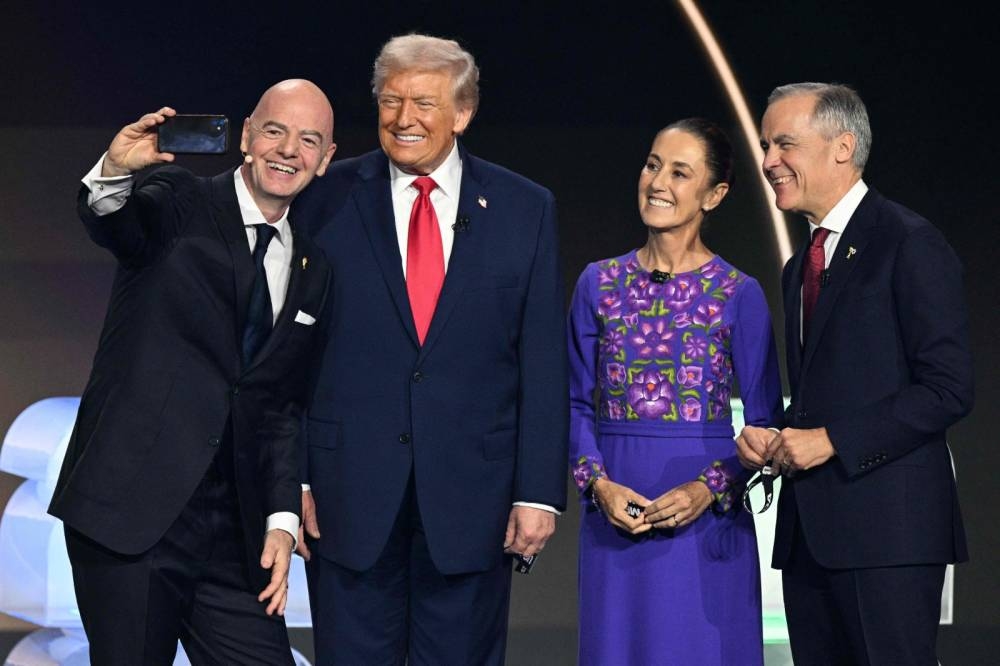 FIFA President Gianni Infantino, US President Donald Trump, Mexico's President Claudia Sheinbaum and Canada's Prime Minister Mark Carney pose for a selfie on stage during the draw for the 2026 FIFA Football World Cup at the Kennedy Centre, in Washington, DC.