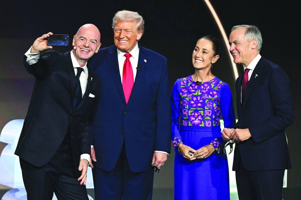 
From left: FIFA President Gianni Infantino, US President Donald Trump, Mexico’s President Claudia Sheinbaum and Canada’s Prime Minister Mark Carney pose for a selfie on stage during the draw for the 2026 FIFA Football World Cup in Washington, DC. (AFP) 