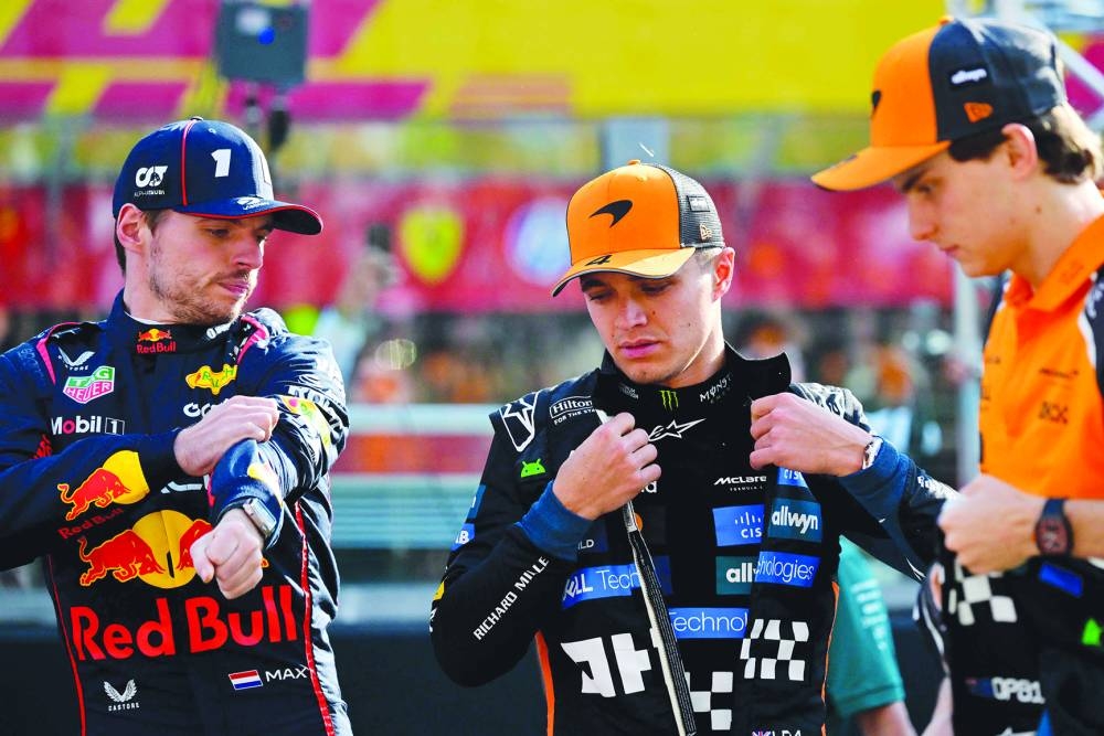 
Red Bull Racing’s Dutch driver Max Verstappen, McLaren’s British driver Lando Norris and McLaren’s Australian driver Oscar Piastri stand on the grid ahead of the Abu Dhabi Grand Prix at the Yas Marina Circuit in Abu Dhabi on Sunday. (AFP) 