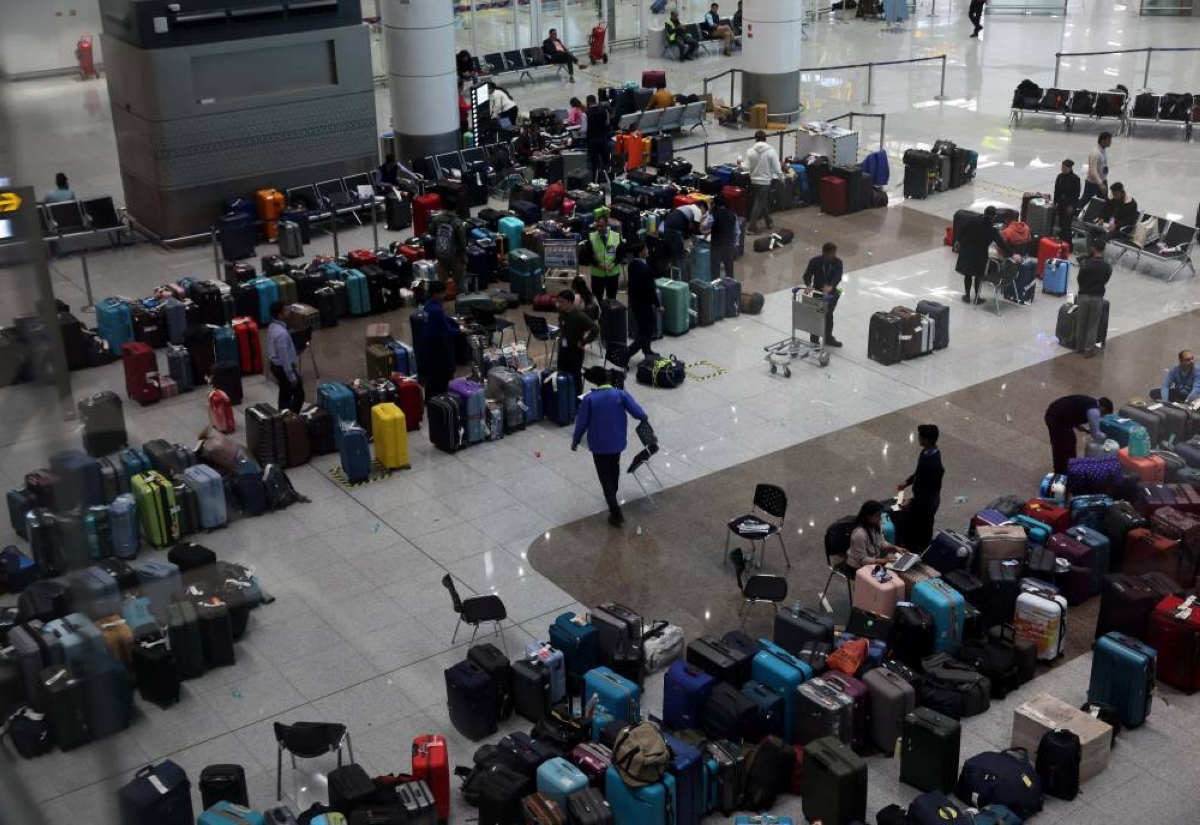 Staff members of IndiGo tag stranded bags and belongings of IndiGo passengers following large-scale flight disruptions, at Terminal 1 of Indira Gandhi International Airport in New Delhi, India, December 8, 2025. REUTERS