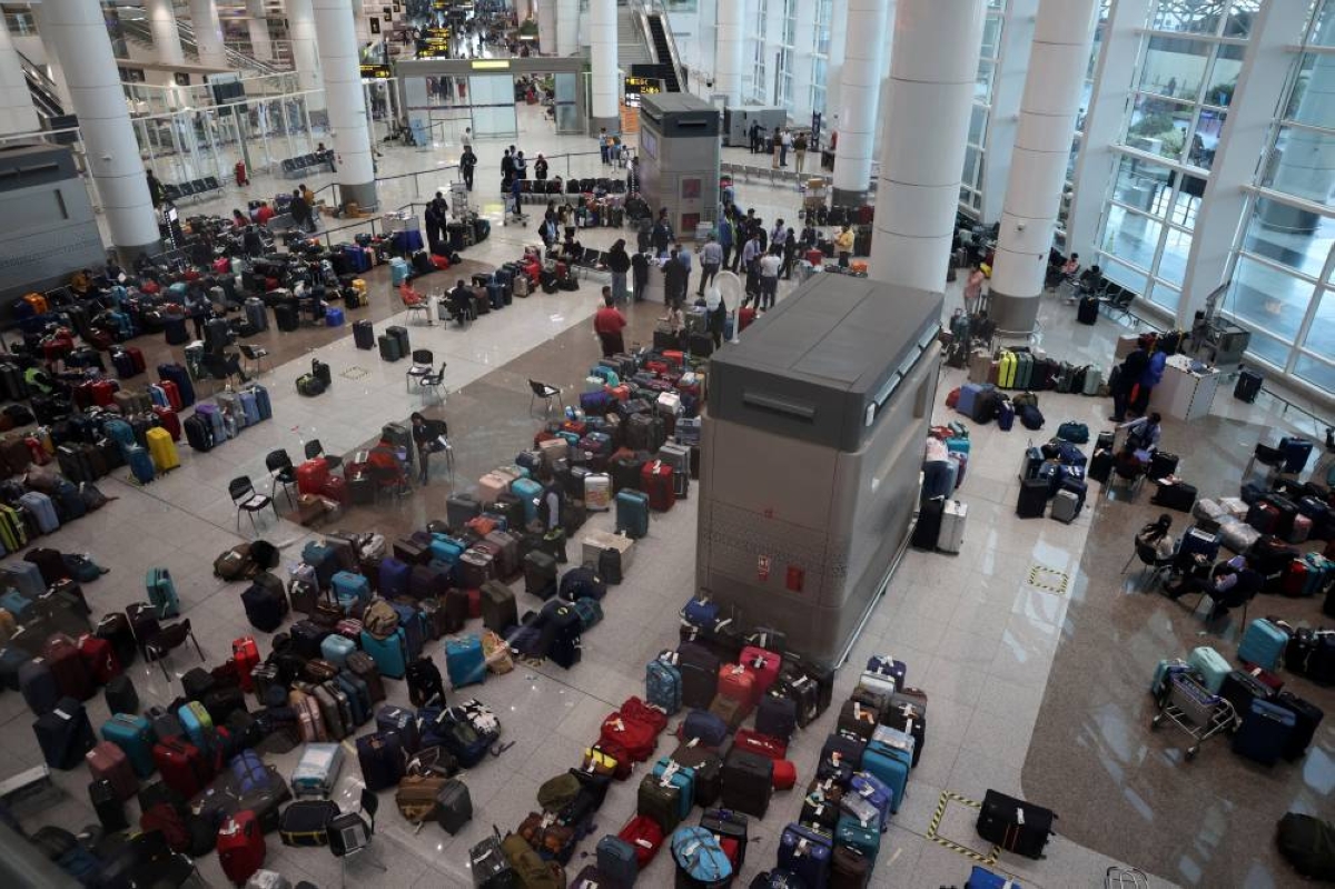Staff members of IndiGo tag stranded bags and belongings of IndiGo passengers following large-scale flight disruptions, at Terminal 1 of Indira Gandhi International Airport in New Delhi, India, December 8, 2025. REUTERS
