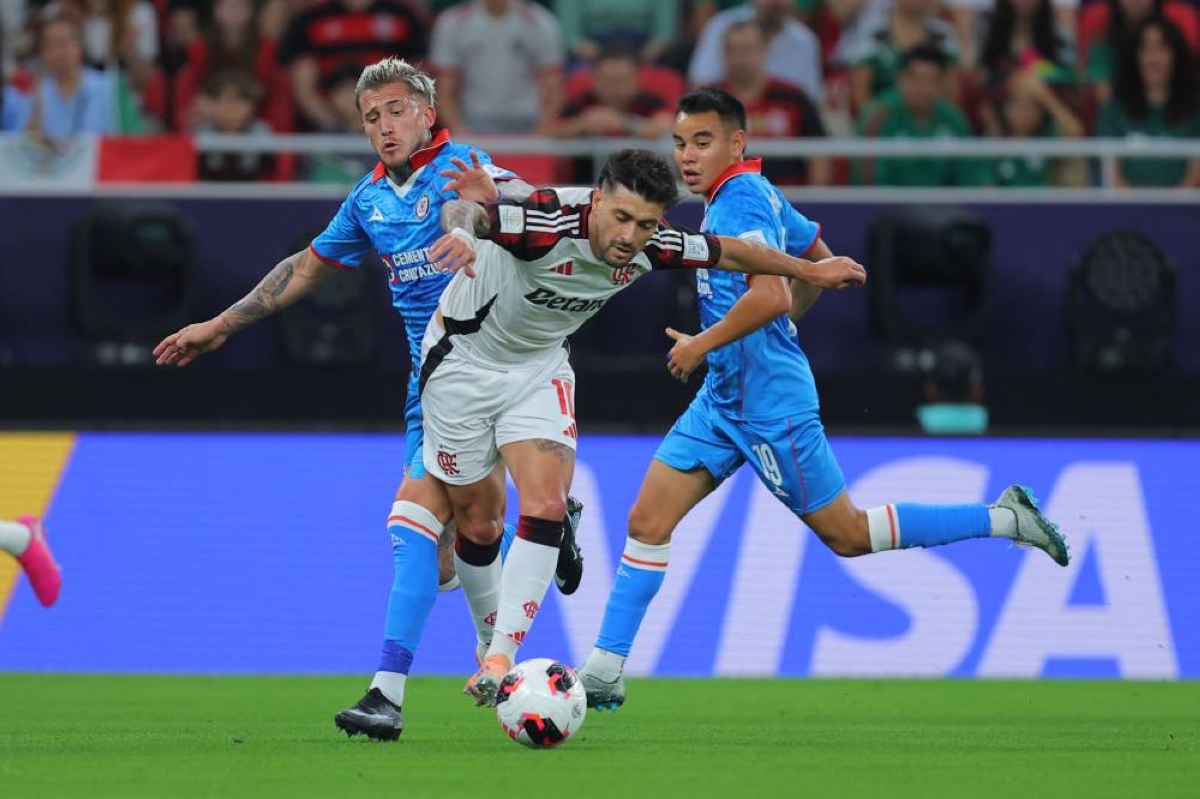 Flamengo's Giorgian de Arrascaeta #10 (C) is challenged by Cruz Azul's Gonzalo Piovi #33 (L) and Carlos Rodriguez #19 (R) during the 2025 FIFA Intercontinental Cup match between Cruz Azul and Flamengo at Ahmad Bin Ali Stadium in Doha on December 10, 2025. (AFP)