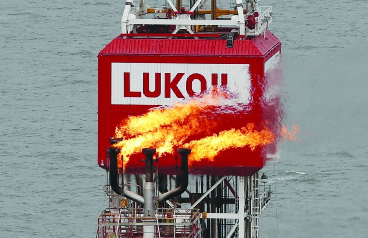 A gas torch is seen next to the Lukoil company sign at the Filanovskogo oil platform in the Caspian Sea, Russia. Russian export revenues hit their lowest in November since the full-scale invasion of Ukraine in 2022, the IEA said.