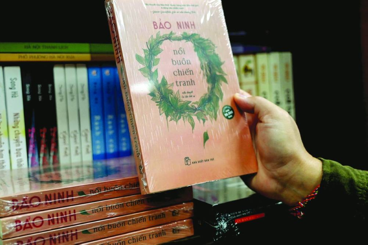 This photo shows a man holding the book *The Sorrow of War in a bookstore in Hanoi. – AFP