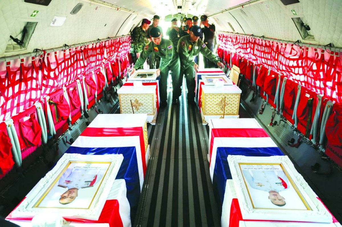 Military personnel arrange coffins of slain soldiers, covered by Thai national flags, during a ceremony yesterday to transport bodies to their home town, inside a military aircraft at a military airport, following deadly clashes between Thailand and Cambodia along a disputed border area, in Ubon Ratchathani province, Thailand. – Reuters