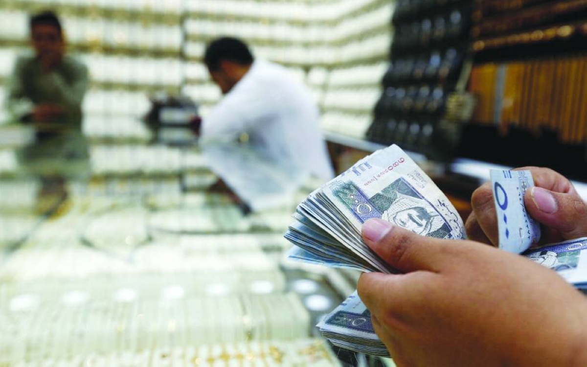 A man counts Saudi riyal banknotes in a jewellery store story in Riyadh (file).