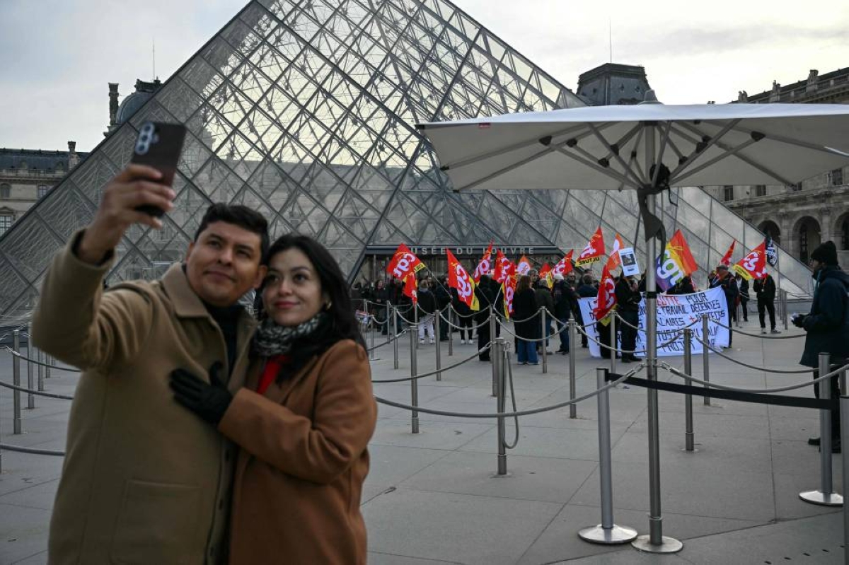 A couple take a selfie outside the closed Louvre Museum as museum workers strike against increasingly deteriorating working conditions and the declining visitor experience at the world famous museum, in Paris yesterday. The Louvre Museum remained closed due to an indefinite strike by its staff, voted on unanimously, a further blow for an institution reeling from the October 19th burglary and the exposure of its shortcomings.