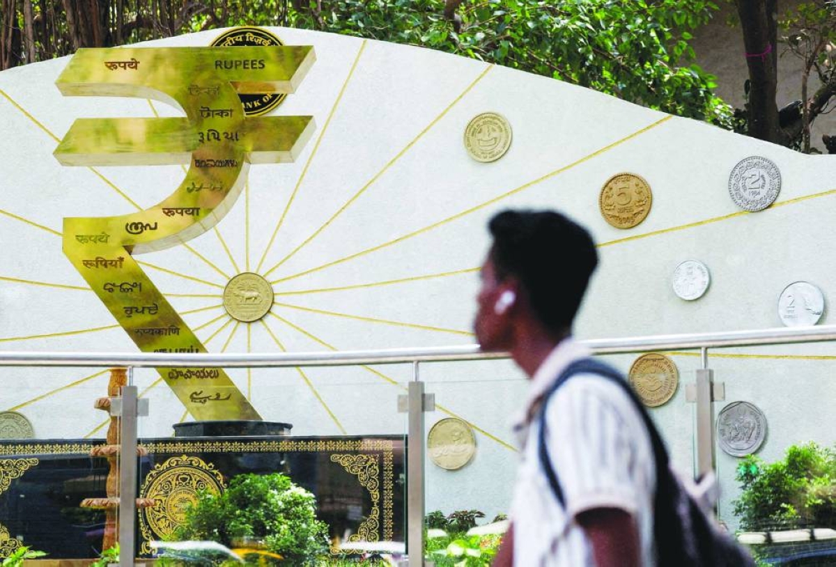 A man walks past an installation of the rupee logo and Indian currency coins outside the Reserve Bank of India (RBI) headquarters in Mumbai. Asia’s worst-performing currency this year has become a near-term risk for Indian stocks, tempering optimism driven by strong economic growth and improving corporate earnings.