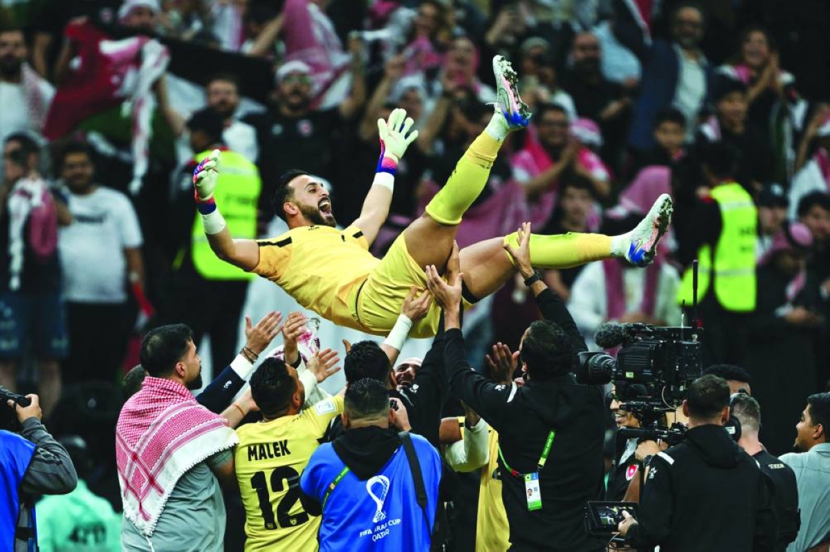 Jordan's players celebrate with goalkeeper Yazeed Abulaila after winning the FIFA Arab Cup 2025 semi-final against Saudi Arabia at the Al Bayt Stadium in Al Khor on Monday. (AFP)