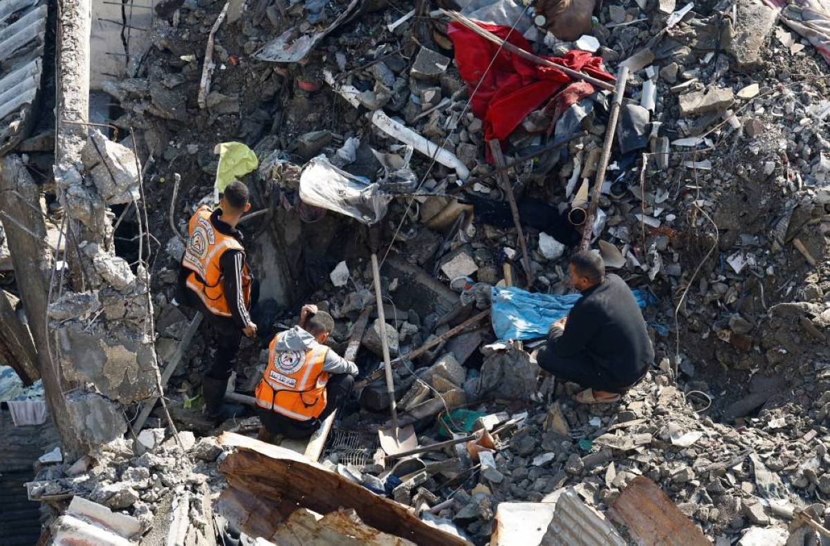 A man watches as members of the Palestinian Civil Defence participate in a search and rescue operation at the site of a house that was partially destroyed during the war and collapsed on Tuesday, at Shati refugee camp in Gaza City, December 16, 2025. REUTERS