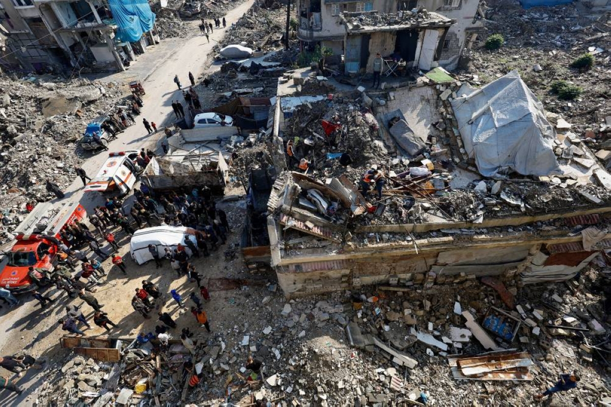 People gather during a search and rescue operation at the site of a house that was partially destroyed during the war and collapsed on Tuesday, at Shati refugee camp in Gaza City, December 16, 2025. REUTERS