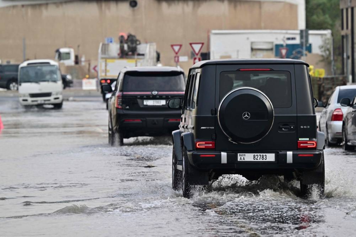 Vehicles drive on a flooded road during heavy rain in the Gulf Emirate of Dubai on December 18, 2025. (AFP)