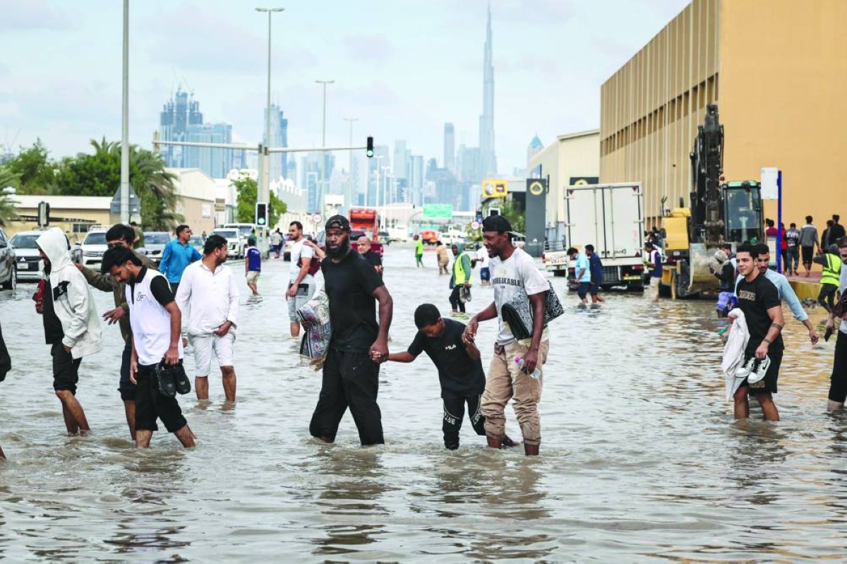 
People wade through floodwaters after heavy rains in Dubai, yesterday. 