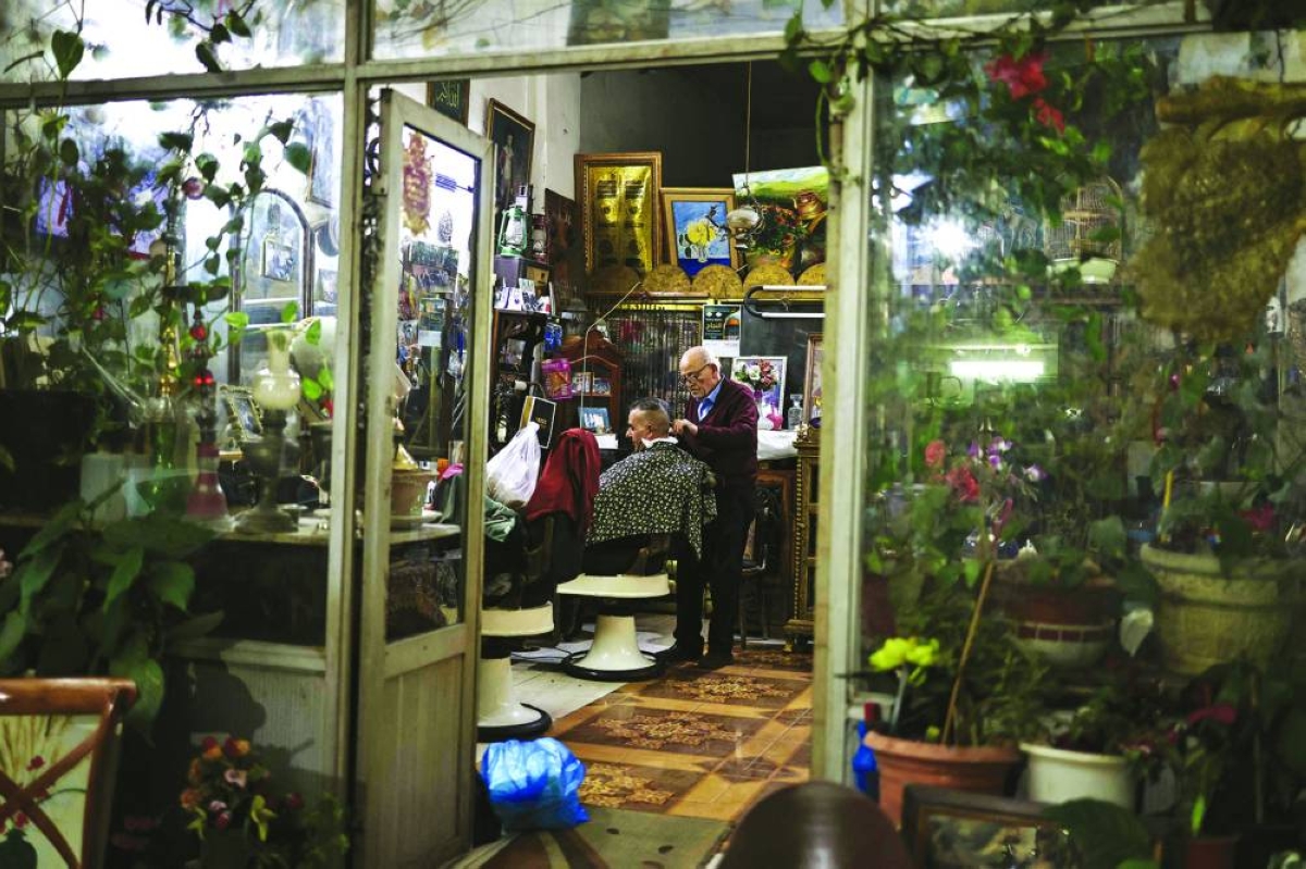 A barber tends to a client in the old city of Nablus in the occupied West Bank. – AFP