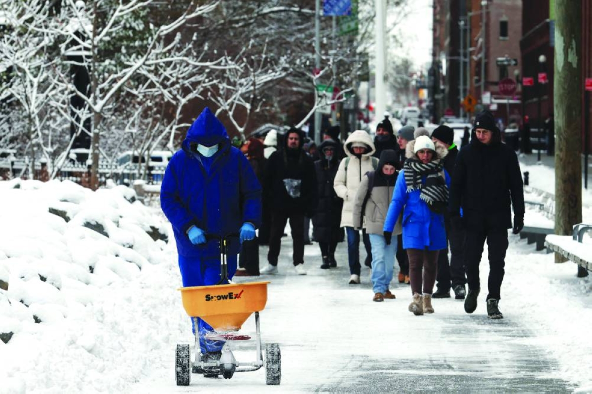 People walk through the snow in Brooklyn after an overnight storm in New York City, Saturday.