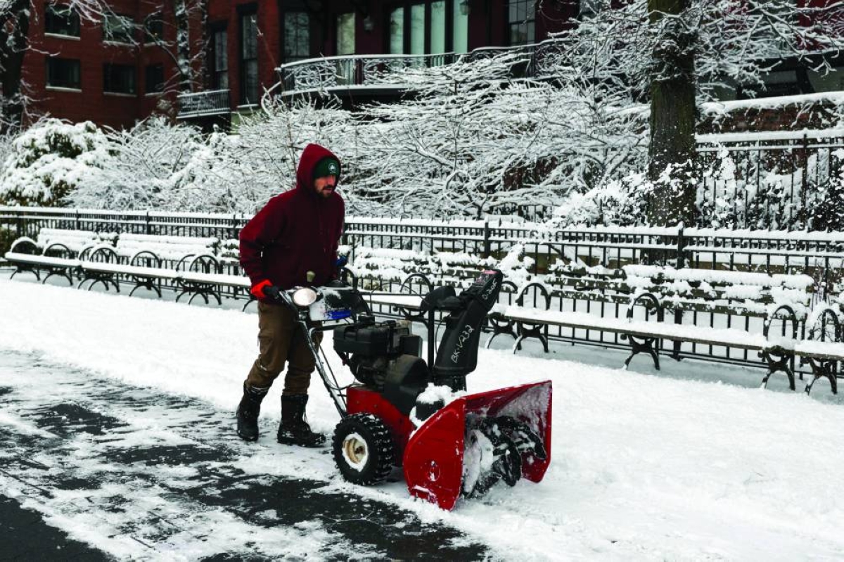 A worker clears a path of snow in New York City, Saturday.