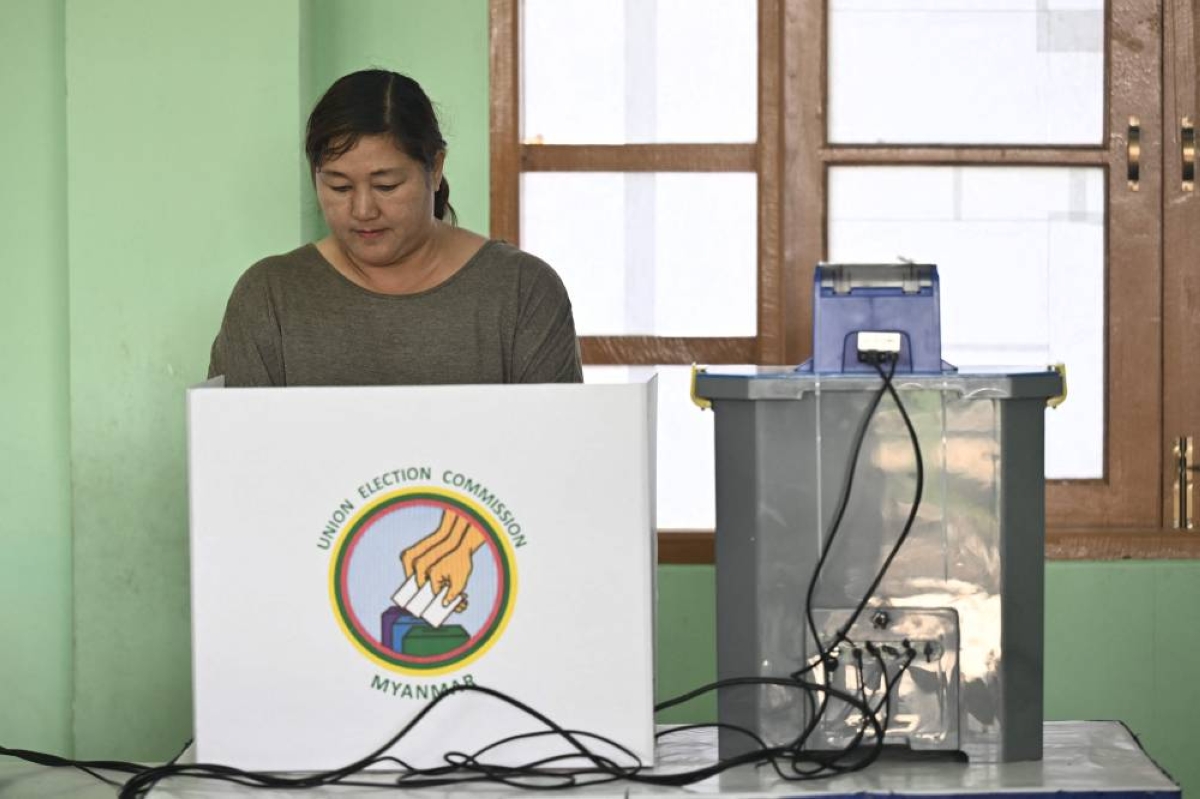 A voter casts her ballot using an electronic voting booth at a polling station during the first phase of Myanmar's general election in Naypyidaw on December 28, 2025. (AFP)