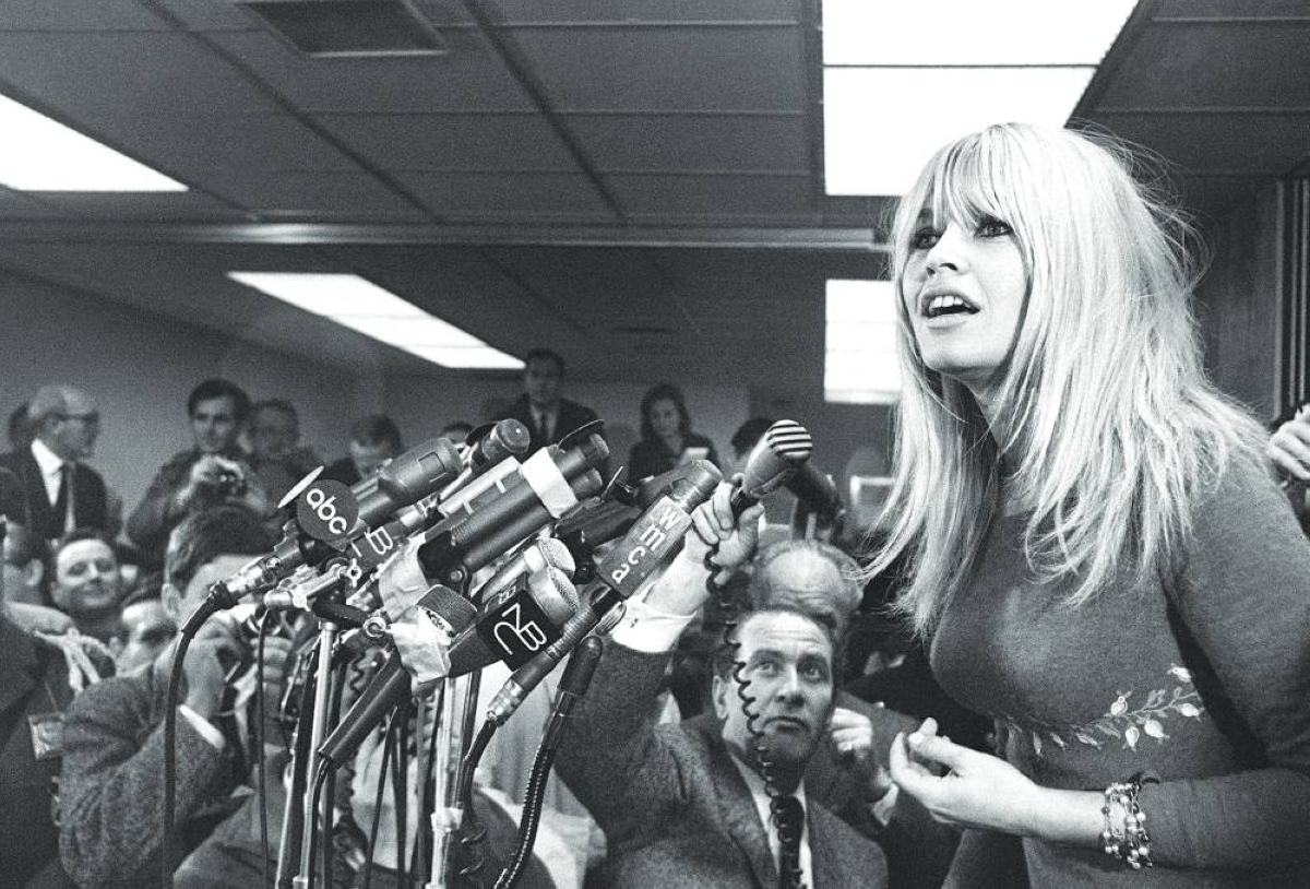 This picture taken on December 17, 1965, shows French actress Brigitte Bardot giving an unplanned press conference upon her arrival at Kennedy airport in New-York, where she came to attend the preview of *Viva Maria, directed by Louis Malle. – AFP