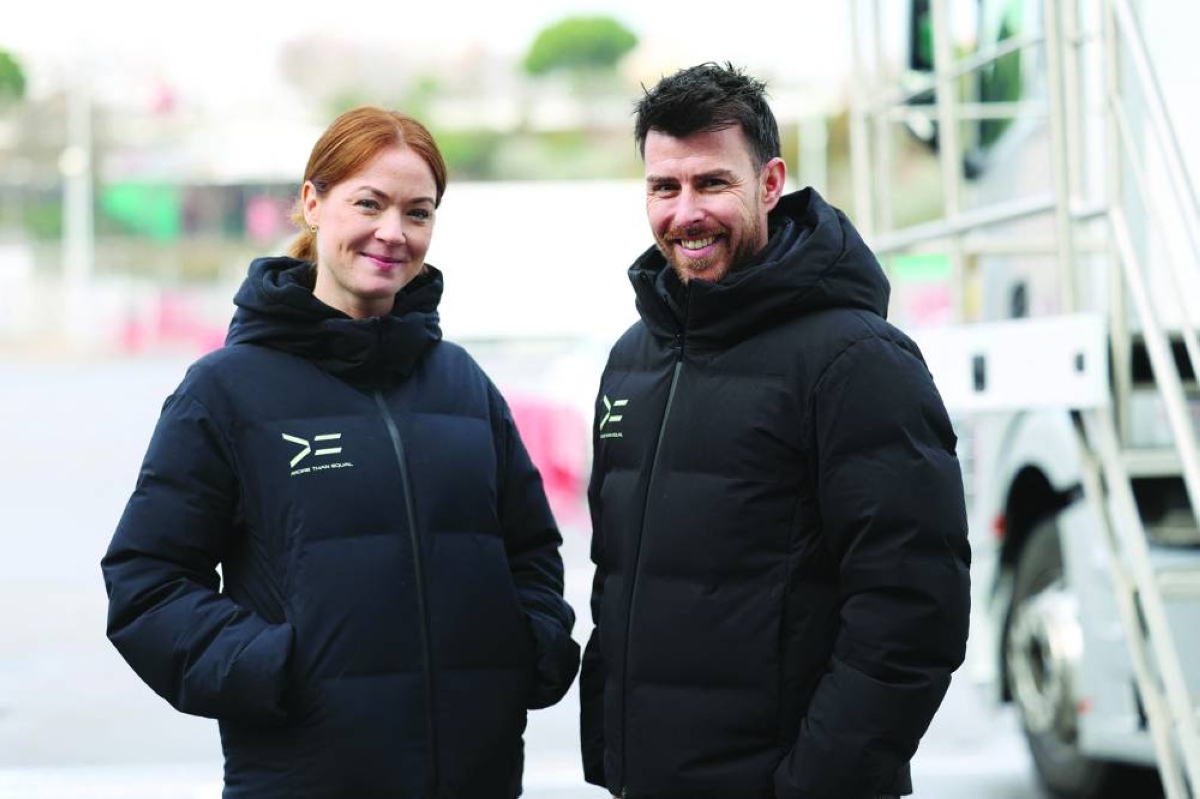 More Than Equal's CEO Tom Stanton (R) and More Than Equal's head of driver development Lauren Forrow pose for a photograph during a test training session at the Circuit de Barcelona-Catalunya in Montmelo, Barcelona province, on December 16, 2025. In the United Kingdom, often described as the cradle of Formula 1, efforts are being made at every level of motorsport to tackle gender inequality on the track and bring more girls into the paddock. (Photo by Lluis GENE / AFP)