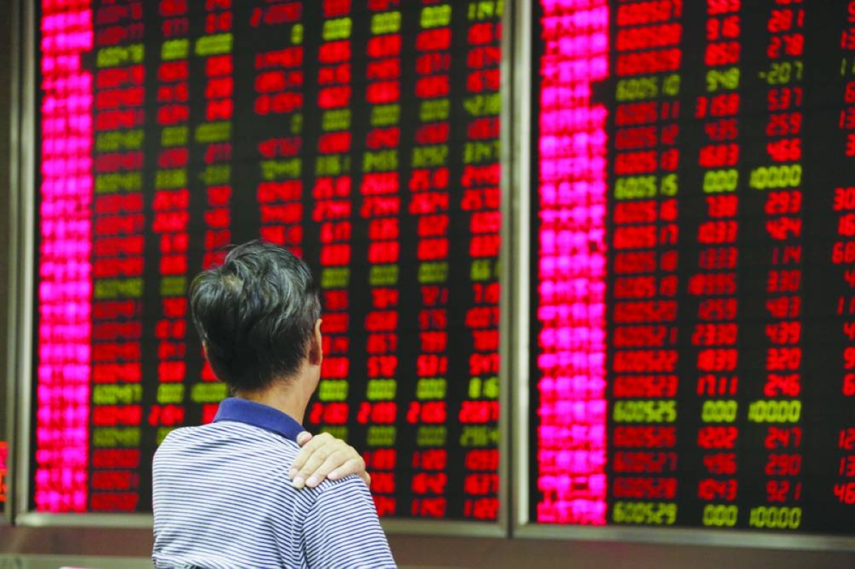An investor looks at an electronic board showing stock information at a brokerage house in Beijing. Shanghai - Composite ended flat at 3,965.12 points Tuesday.