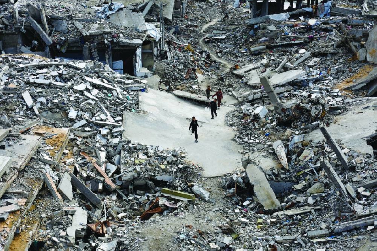 Palestinians children walk among the rubble of residential buildings destroyed during the war, in Jabalia, northern Gaza Strip, Wednesday.