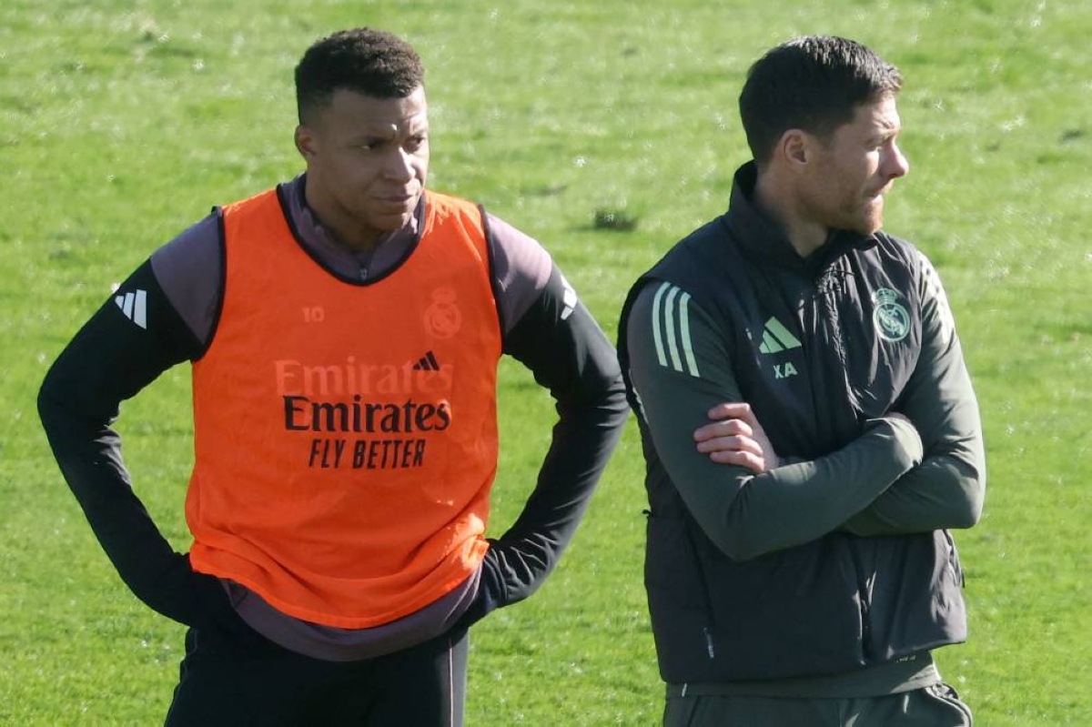 Real Madrid's French forward #10 Kylian Mbappe (L) and Real Madrid's Spanish coach Xabi Alonso attend an open door training session at Real Madrid Sports City in Valdebebas, in the outskirts of Madrid, on December 30, 2025. Real Madrid's French forward, Kylian Mbappe, will be sidelined for at least three weeks due to discomfort in the lateral collateral ligament of one knee, a source close to the player told AFP. (AFP)
