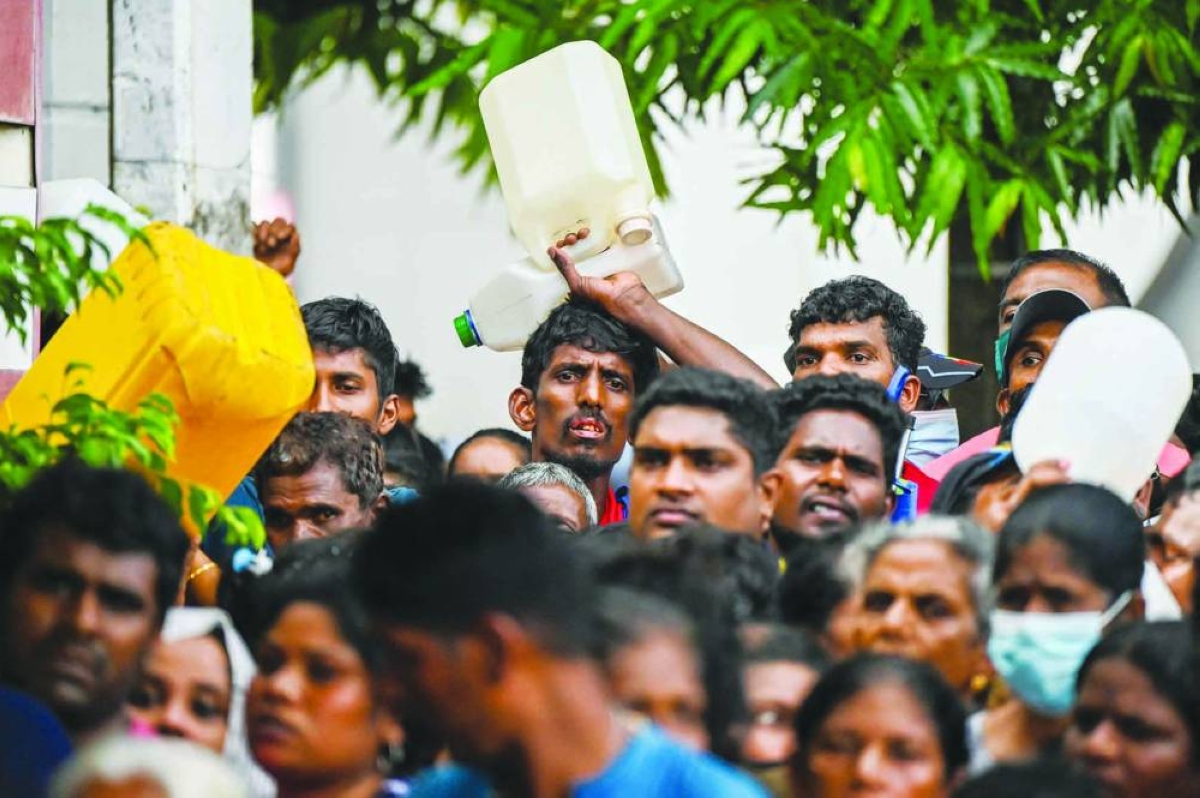 
People queue up to buy kerosene for domestic use at a supply station in Colombo (file). While low inflation may appear positive for consumers, a rate below the central bank’s target signals underlying economic issues including weak consumer demand. 