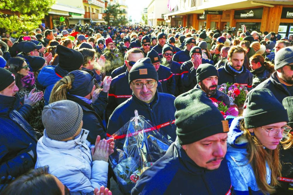 People applaud firefighters who turned up to pay their respects at the makeshift memorial near Le Constellation. Reuters