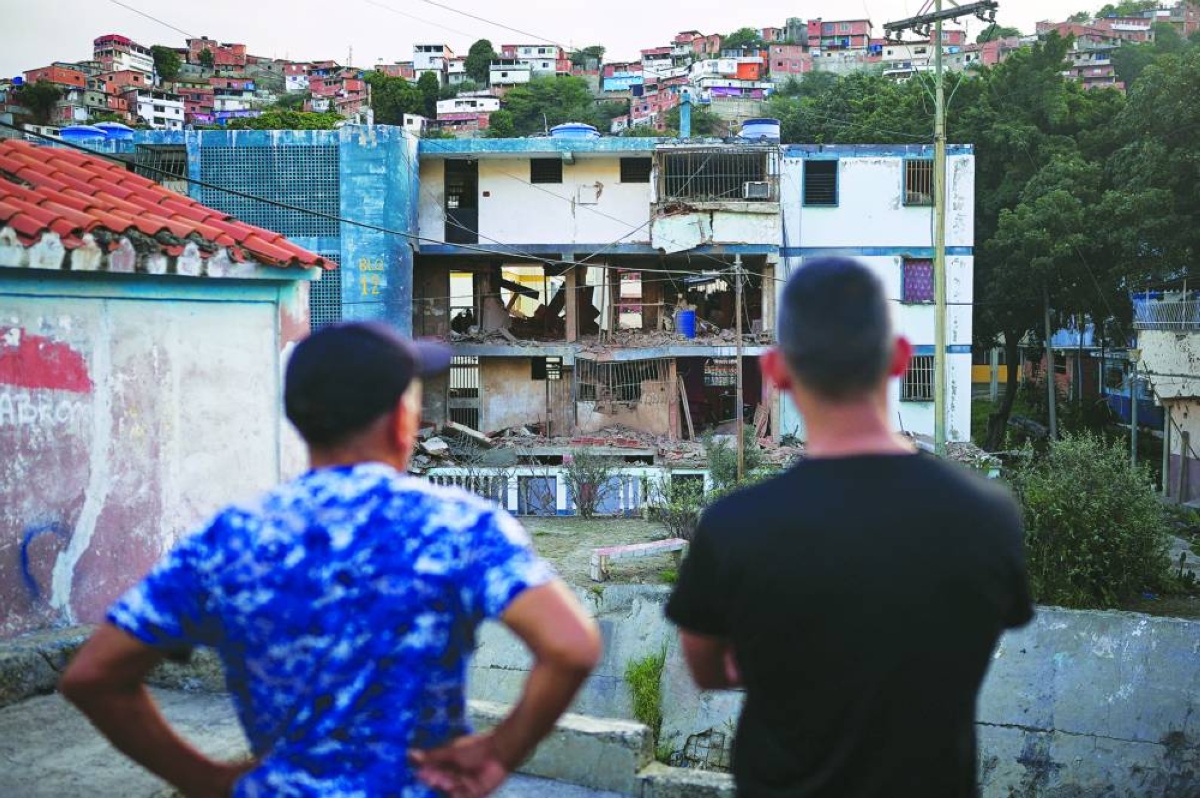 
Two men looks at their damaged apartment building, after the US launched a strike on Venezuela, capturing its President Nicolas Maduro and his wife Cilia Flores, in Catia La Mar, Venezuela, yesterday. 