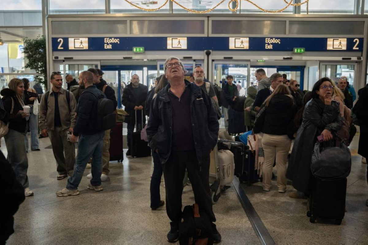 Passengers check screens for flight information as traffic is delayed or reported due to technical issues at a departure hall of Athens' Eleftherios Venizelos international airport in Spata. For a few tense hours on Sunday ‌morning, Greek skies turned into a communications black hole. Air traffic controllers for ‌Athens airport were guiding planes towards ‍the runway when the usual radio chatter suddenly vanished - replaced by a piercing whistle.