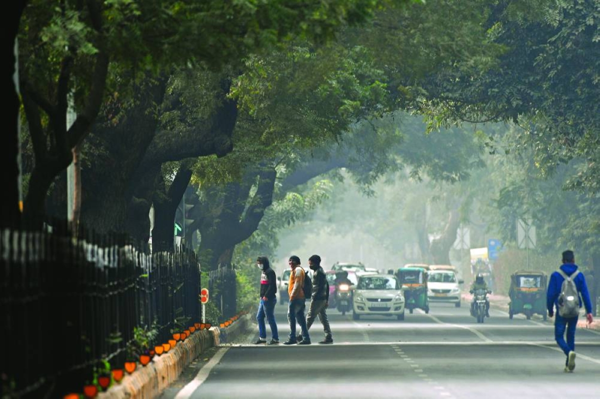 Commuters cross a road amid smoggy conditions in New Delhi (file). India's near $4tn economy is expected to grow 7.4% in ‍the fiscal year ending in March, the National Statistics Office said on Wednesday, above the government's initial projection of 6.3%-6.8%.