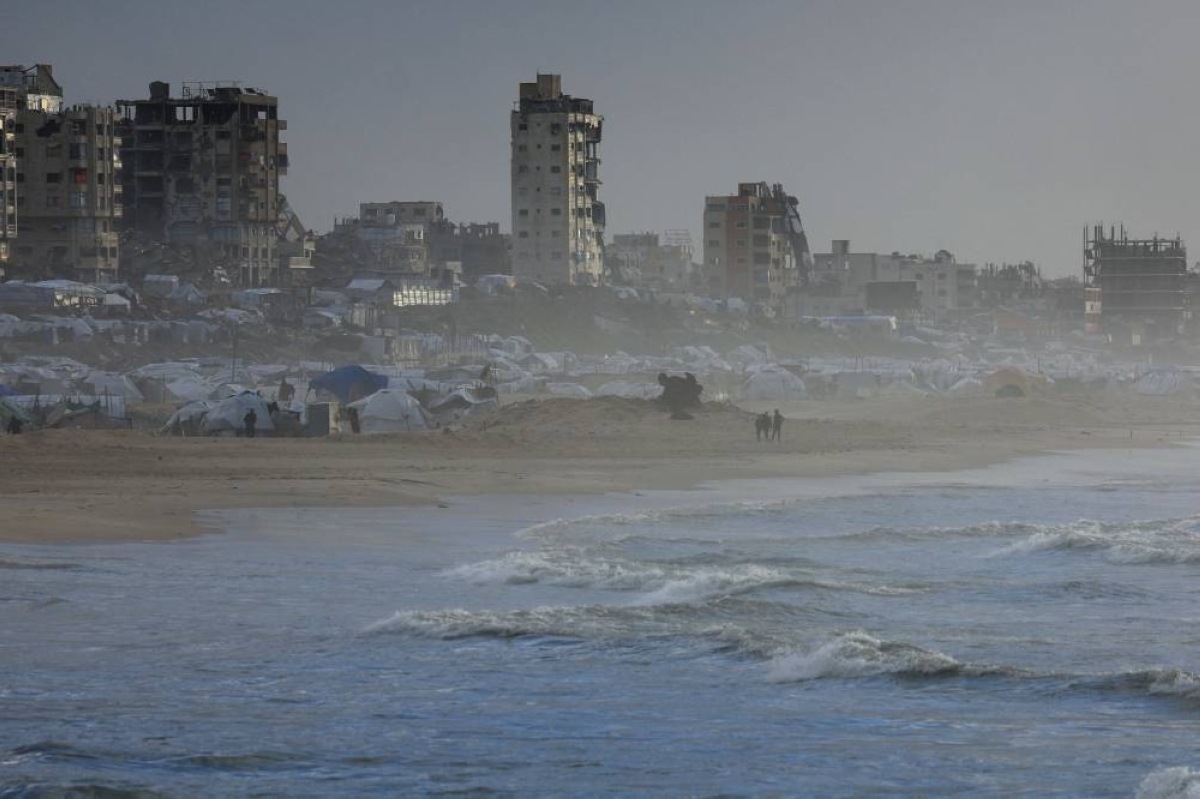 Palestinians walk on a beach during a weather disturbance in Gaza City. REUTERS