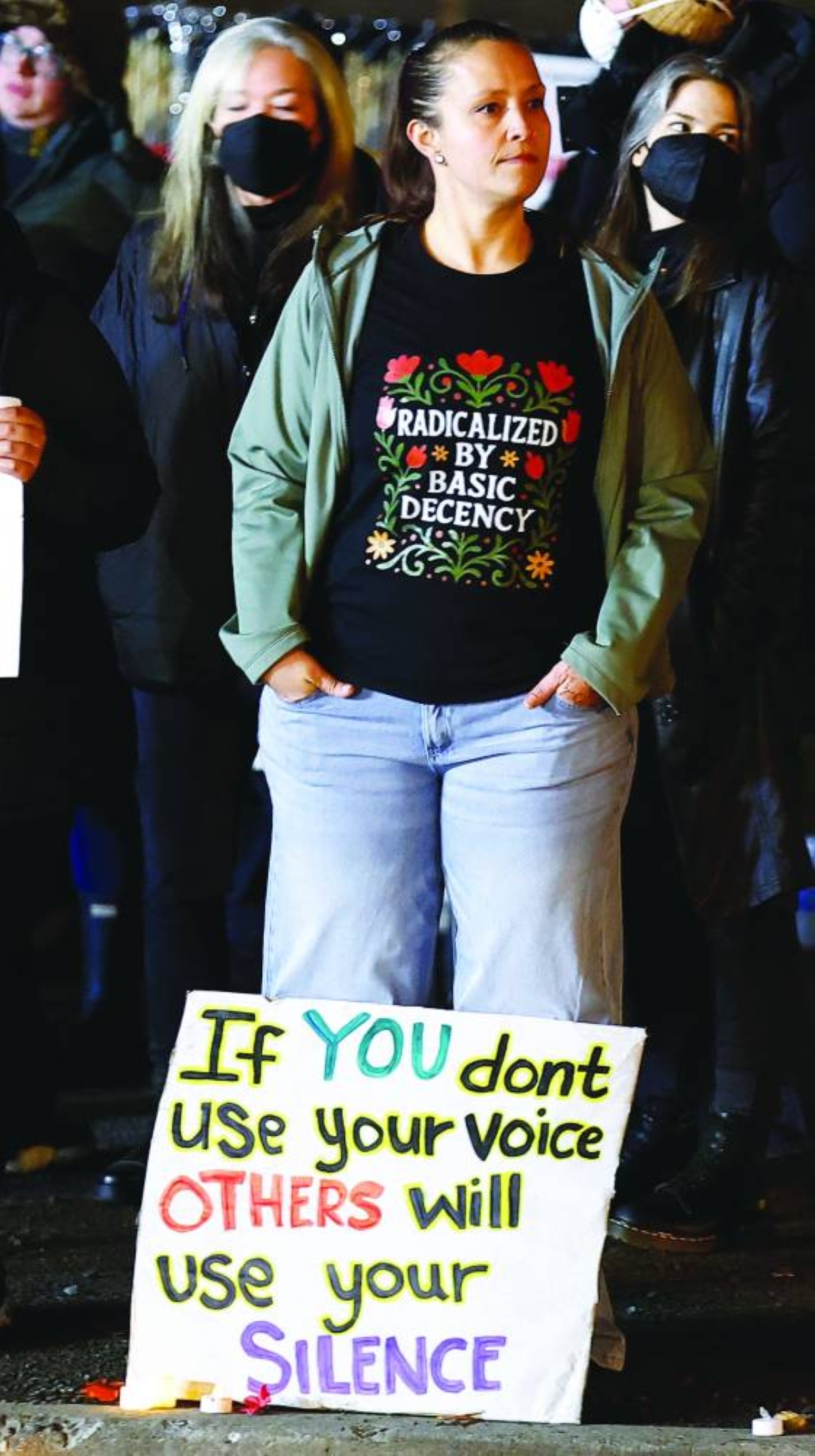 A woman with a sign beside her feet takes part in a protest outside the ICE facility in Portland, Oregon, US. – Reuters
