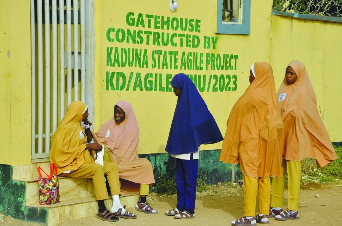 Students gather near the gate of Government Girls Secondary School Maimuna Gwarzo, Tudun Wada, as schools across northern Nigeria reopen nearly two months after closing due to security concerns, in Kaduna, Monday.