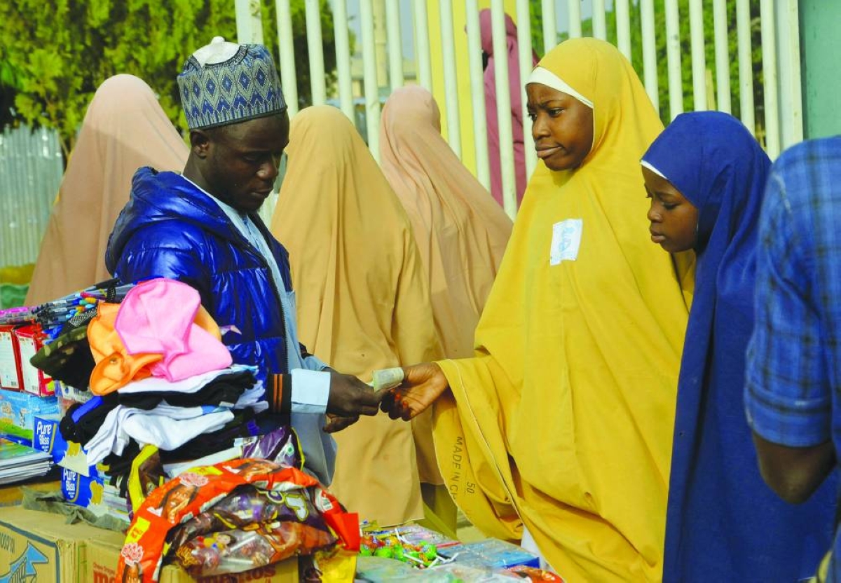 Students buy school items near the gate of Government Girls Secondary School Maimuna Gwarzo, Tudun Wada, as schools across northern Nigeria reopen nearly two months after closing due to security concerns,in Kaduna, Monday.