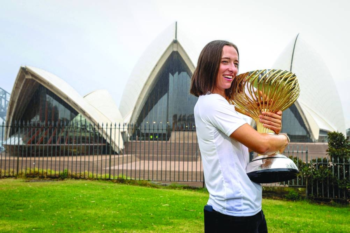 Team Poland's Iga Swiatek poses with the United Cup trophy in front of the Sydney Opera House on January 12, 2026, after they won the United Cup tennis tournament. (AFP)