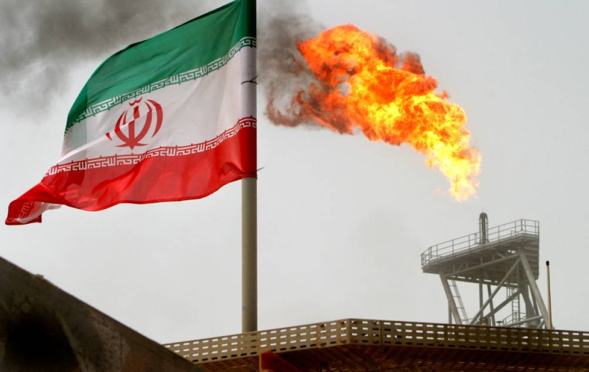 A gas flare on an oil production platform in the Soroush oil fields is seen alongside an Iranian flag. Iran remains one of the world's top ten oil producers even though its output has fallen sharply since the 1970s, hit in particular by rounds of US sanctions.