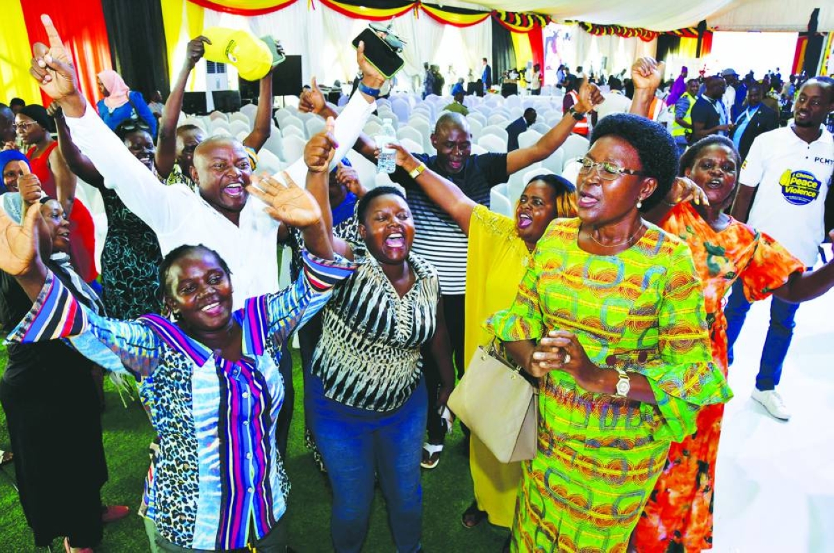 Supporters of Ugandan President Yoweri Museveni celebrate as the Ugandan Electoral Commission (EC) Chairperson Justice Simon Byabakama announces the final presidential results, following the general elections at the Tally Centre in Lubowa, Wakiso district near Kampala, Saturday.