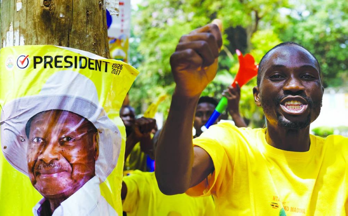 A supporter of Uganda's President and leader of the ruling National Resistance Movement (NRM) party, Yoweri Museveni, celebrates  in Kampala, Uganda, Saturday.
