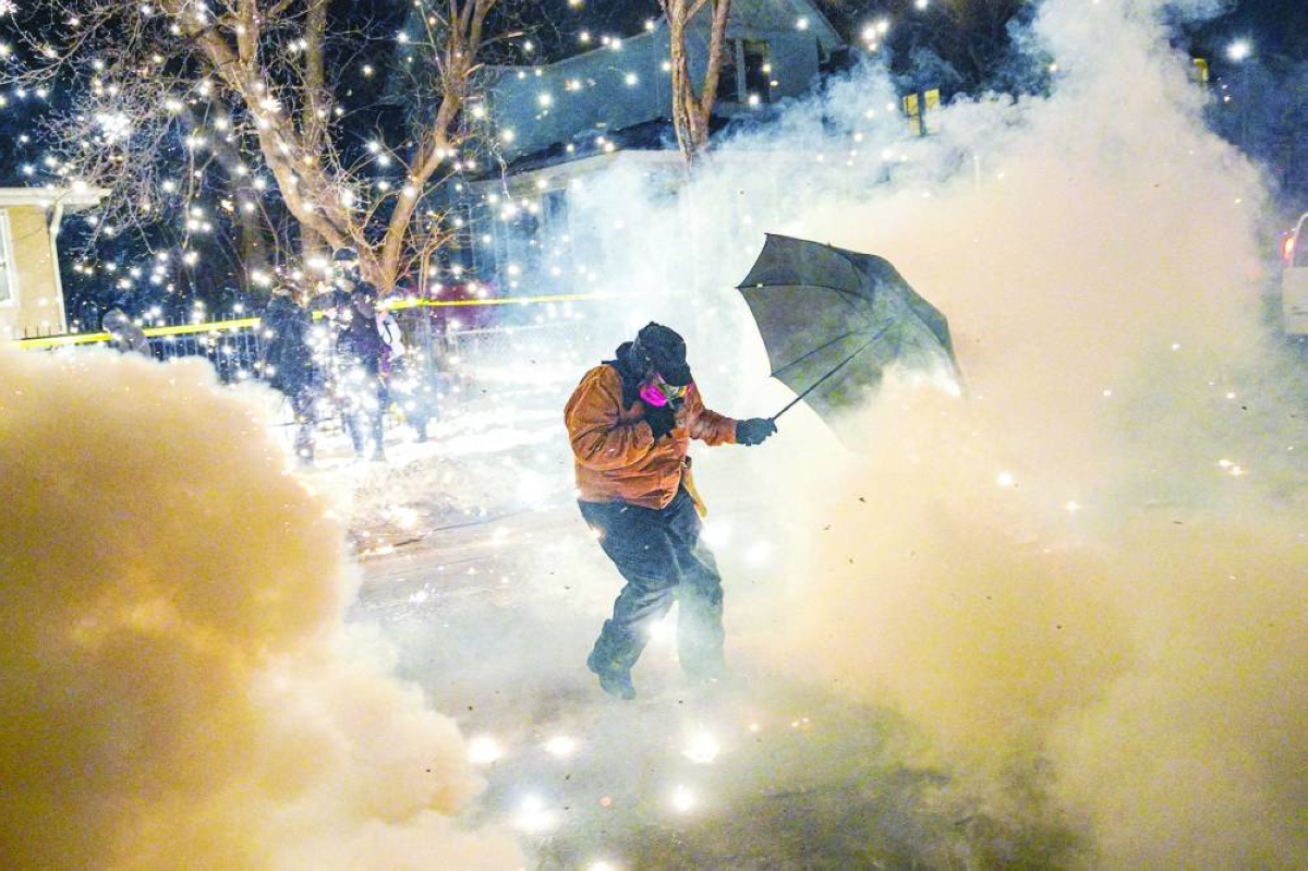 A protesting community member reacts as federal agents fire munitions and pepper balls in north Minneapolis, Minnesota. Reuters
