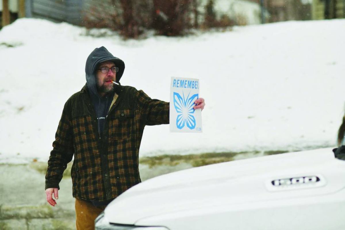 A man shows federal agents sitting in their parked truck a sign reading ‘Remember’ in the Frogtown neighbourhood in St Paul, Minnesota. AFP