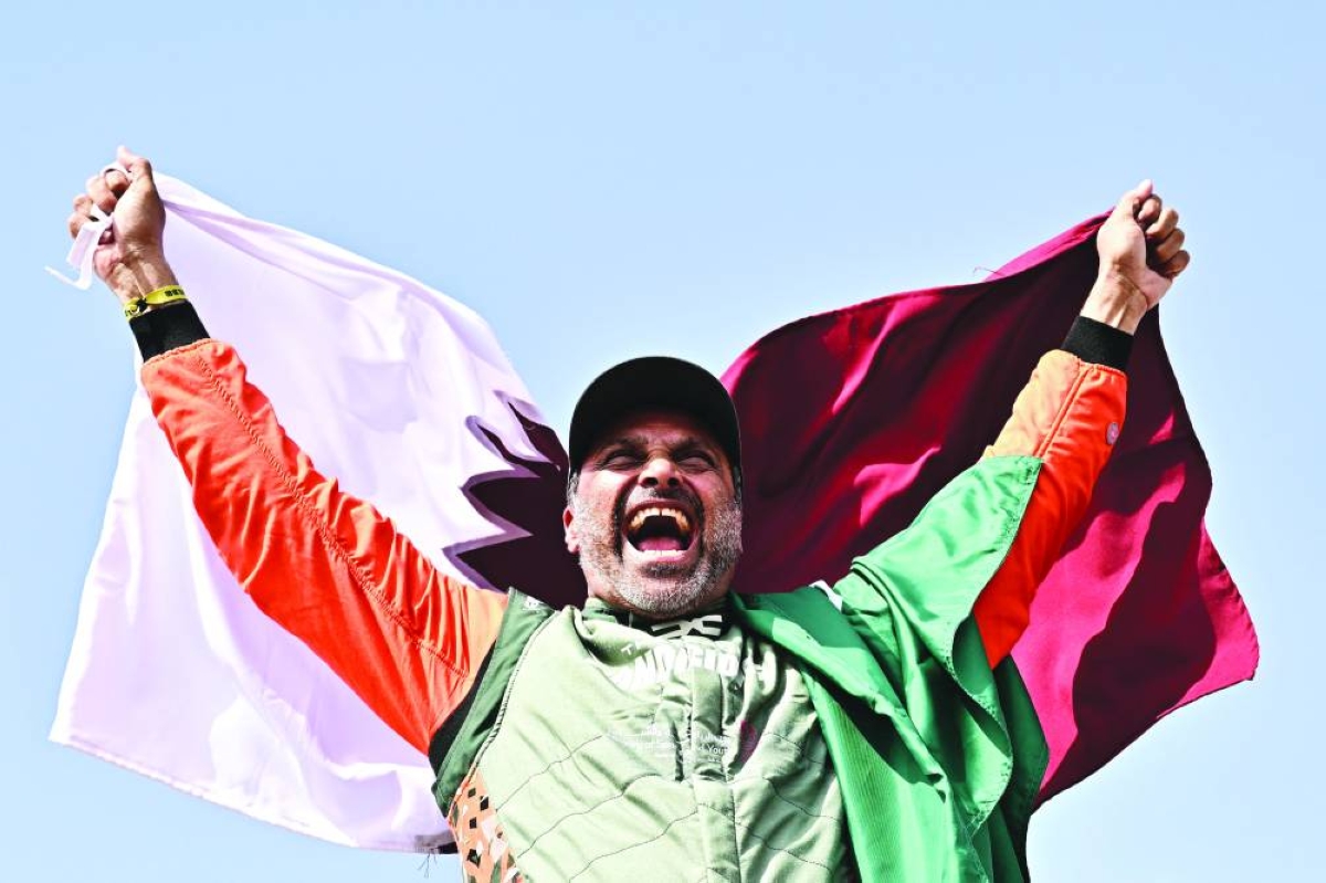 Nasser al-Attiyah holds Qatar's flag while celebrating his win in the 48th edition of the Dakar Rally 2026 in Yanbu, Saudi Arabia, Saturday. (AFP)